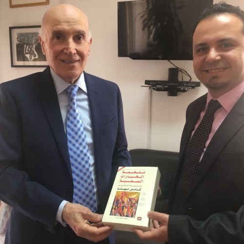 President of , Amel Association International , Dr. Kamel Mhanna, Presents a Book to Dr. Hassan Tajideen